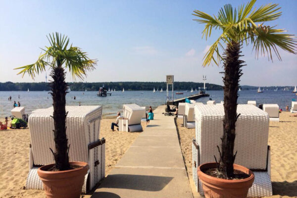 Strand vom Wannsee mit Strandkörben und Palmen mit Blick auf das Wasser