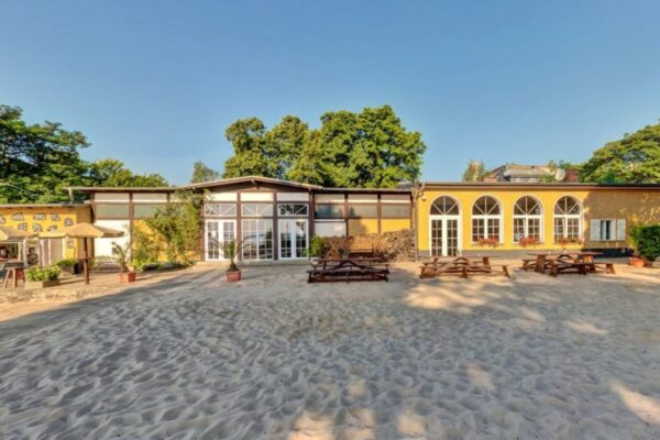 Eventlocation am Strandbad Friedrichshagen mit hellen Sandstrand im Vordergrund